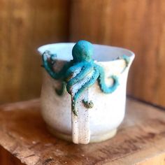 an octopus is sitting on top of a cup