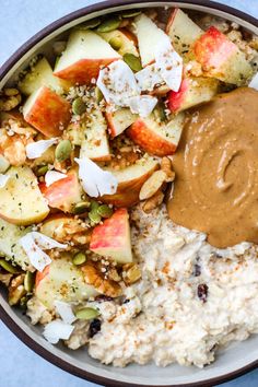 a bowl filled with oatmeal, apples and nuts