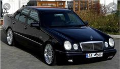 a black mercedes parked in front of a house