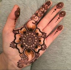 a woman's hand with henna tattoos on it