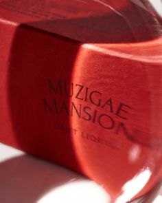 a close up of a red object on a white surface with the words muzigae mansion printed on it