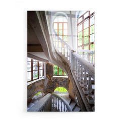 a spiral staircase in an old building with windows