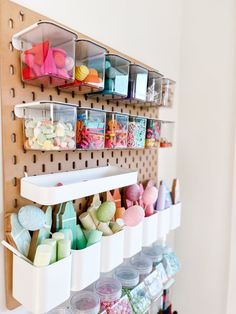 a wall mounted craft supply rack filled with lots of craft supplies and storage bins