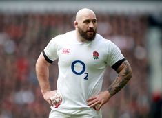 a man with a bald head wearing a rugby jersey and holding a ball in his hands