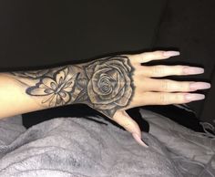 a woman's hand with a rose tattoo on it