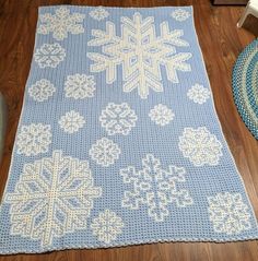 a crocheted snowflake rug on the floor next to a blue chair