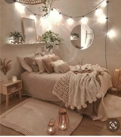 a bedroom with white walls and lots of lights on the headboard, rugs and bedding