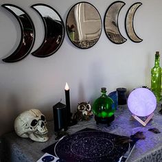 a table topped with plates and bottles next to a wall mounted moon phases on the wall