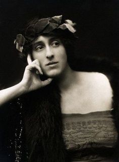 an old photo of a woman with a fur stoler on her head talking on the phone