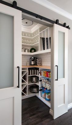 an open pantry with white doors and shelves