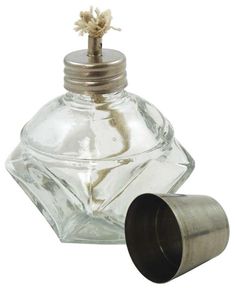 an empty glass bottle with a metal stopper on the top and a flower sticking out of it