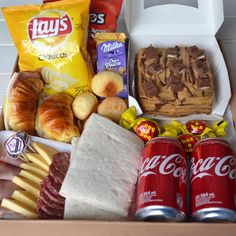 an open box filled with snacks, bread and other items to make a good snack