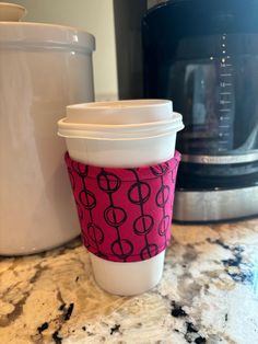 a coffee cup sitting on top of a counter next to a blender