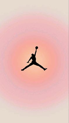 the silhouette of a person jumping up into the air in front of an orange and pink sky