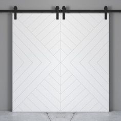 an open white sliding door in a room with concrete flooring and black metal bars