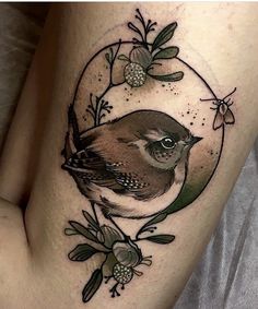 a bird sitting on top of a tree branch with leaves and berries in the background