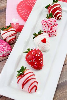 four strawberries are arranged on a white plate