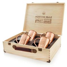 three moscow mule mugs in a wooden box with leather straps on the bottom and inside