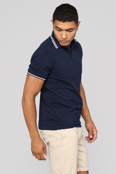 a young man in a polo shirt and khaki shorts