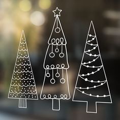 three hand drawn christmas trees on a window