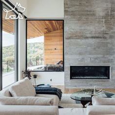 a living room filled with furniture and a fire place in front of a large window