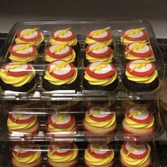 cupcakes in plastic containers with yellow and red frosting