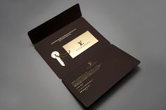 an open folder with a key on it and a card attached to the front cover