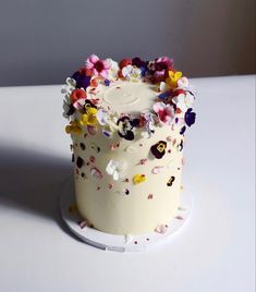 a cake with white frosting and colorful flowers on it