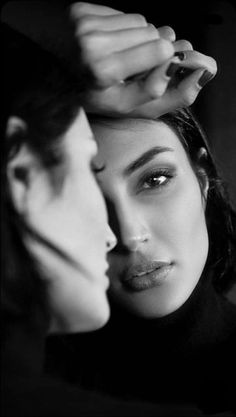 two women are touching their foreheads in black and white