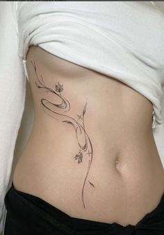 a woman's stomach with a flower tattoo on her belly and the bottom part of her abdomen