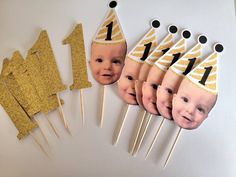 a table topped with cake toppers and pictures of baby's first birthdays