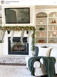 a living room decorated for christmas with stockings hung over the fire place and wreaths on the mantle