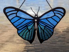 a stained glass butterfly hanging on a chain