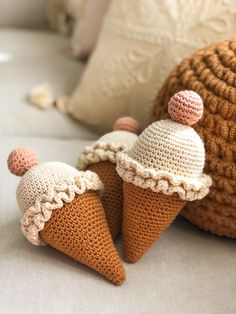 two crocheted ice cream cones sitting next to each other on top of a couch