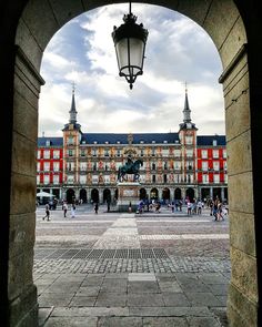 an archway leading to a large building with people walking around it