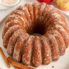 an apple cider bundt cake on a plate with cinnamon sticks