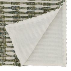 a white and green blanket folded on top of each other with circles in the middle