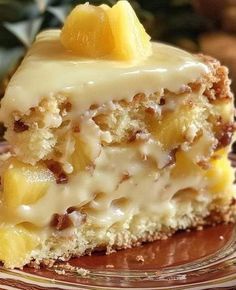 a piece of cake with white frosting and pineapples on top is sitting on a plate