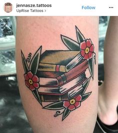 a tattoo with books and flowers on it