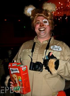 a man dressed in costume holding a cat and smiling at the camera with his mouth open