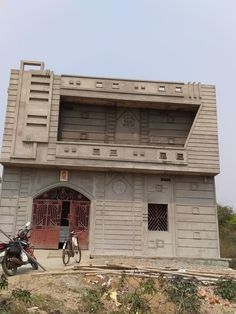 a motorcycle parked in front of a building with an open door on the top floor