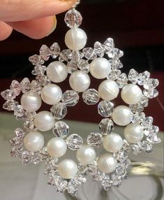 a close up of a brooch with pearls and diamonds on it's side