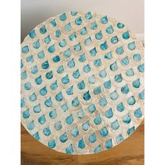 a blue and white plate on top of a wooden table next to a brown floor