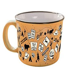 a yellow and black coffee mug with various stickers on the inside, in front of a white background