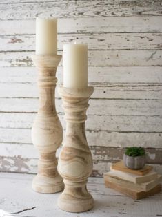 two wooden candlesticks sitting next to each other on top of a white table