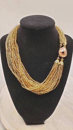 "This is a beautiful golden brown seed bead parure, comprised of clip-on earrings, multi-strand necklace and bracelet. All pieces are marked Japan.  Necklace is :17-1/2\"x1-1/2\" Bracelet is :7-1/2\"x1-1/2\" Earrings are 1\"rnd" Elegant Multi-strand Gold Beads, Brown Multi-strand Beaded Necklace With Gold Beads, Brown Gold Beads Multi-strand Necklace, Gold Multi-strand Jewelry With Polished Beads, Multi-strand Gold Beads Costume Jewelry, Adjustable Double Strand Gold Beads, Gold Polished Double Strand Beads, Gold Double Strand Polished Beads, Elegant Double Strand Gold Beads