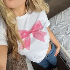 Pink Bow Graphic White Tee Be effortlessly cute in our Pink Bow Graphic White Tee. Featuring a kawaii pink bow graphic, this tee adds the perfect touch of femininity to your wardrobe. Made with soft fabric for all-day comfort. Size: S: Bust: 76cm/ 29.9?in, Length: 42cm/?16.5 in M: Bust: 80cm/?31.5 in, Length: 43cm/?16.9 in L: Bust: 84cm/ 33.1 in, Length: 44cm/?17.3 inMaterial:?Cotton Girly Shirt Designs, Bow Tee Shirt, Bow T-shirt, Bow On Clothes, Bow Shirt Outfit, Bow Graphic, 2000s Tops, T Shirts Cute, Geometric Clothing