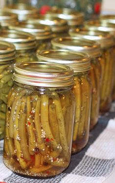 pickles in jars lined up on a table