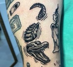 an arm with some tattoos on it and various things in the shape of alligators