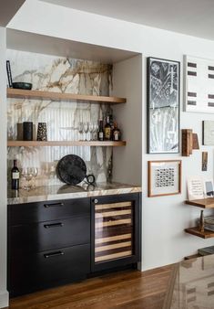 a kitchen with marble counter tops and wooden shelves on either side of the wall is a wine cellar